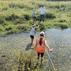 Pupils pond dipping in the stream during a field study
