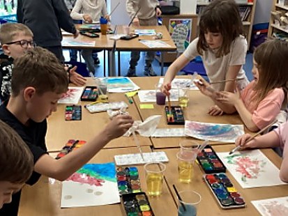 Children painting with watercolours in class