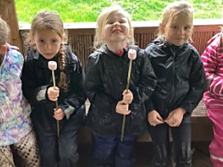Pupils outdoors holding flowers they have grown